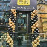 Czarno-złote kolumny balonowe na otwarcie Moli Hotpot & Grill